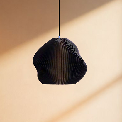 Matte black table lamp with a smooth rounded form and soft glow