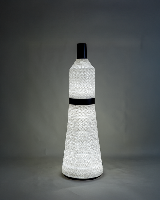 Tall floor lamp with a tapered textured surface and warm light